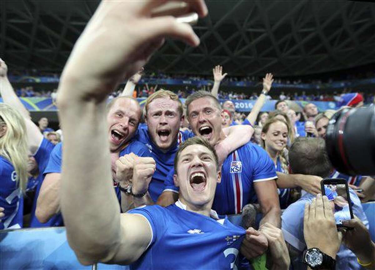 El lateral islandés Haukur Heidar Hauksson se saca una foto con simpatizantes de su selección tras vencer 2-1 a Inglaterra en los octavos final de la Eurocopa en Niza, Francia, el lunes 27 de junio de 2016. (AP Foto/Claude Paris)