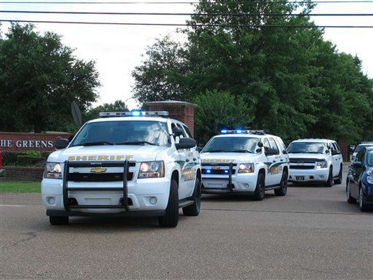 Varias camionetas de la policía del condado de Shelby parten de un vecindario cercado donde fueron hallados cuatro niños muertos a cuchilladas el viernes 1 de julio de 2016 en los suburbios de Memphis, Tennessee. (AP Foto/Adrian Sainz)