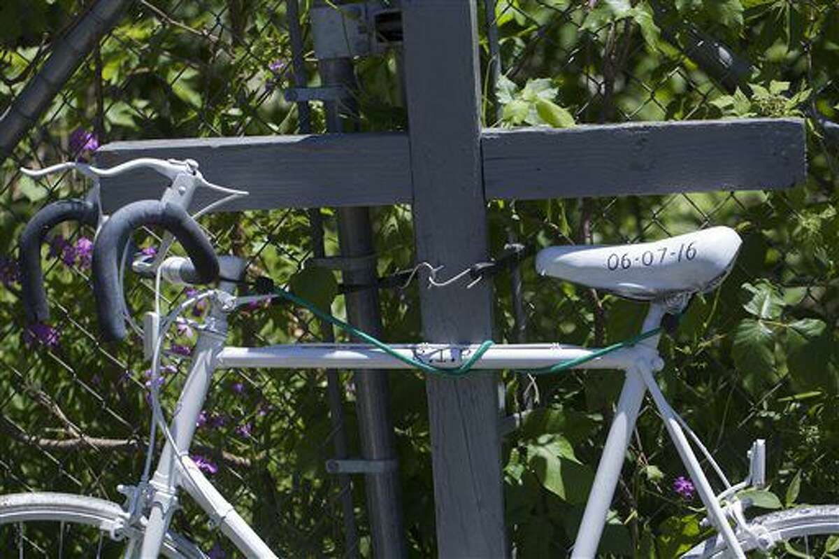 A ghost bike is displayed as a memorial Wednesday, June 8, 2016, in Cooper Township, Mich., where five bicyclists where killed and four where injured by an oncoming vehicle. A prosecutor says police were seeking a pickup truck due to reports that it was driving erratically minutes before five adults in a group of bicyclists were struck and killed on a street in western Michigan the night before. (Tom Brenner/The Grand Rapids Press via AP) ALL LOCAL TELEVISION OUT; LOCAL TELEVISION INTERNET OUT; MANDATORY CREDIT