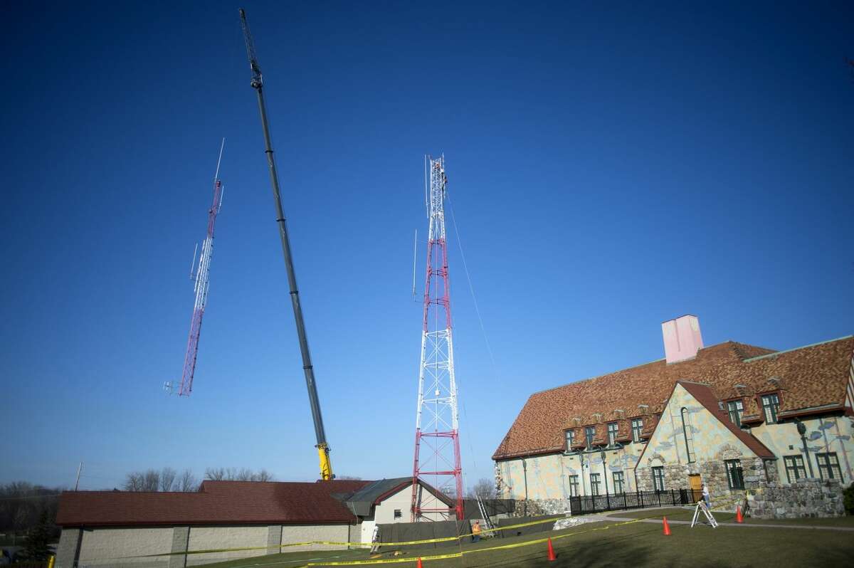 Crew members from Iseler Demolition work to raze the radio tower next to the Midland County Courthouse on Friday morning.