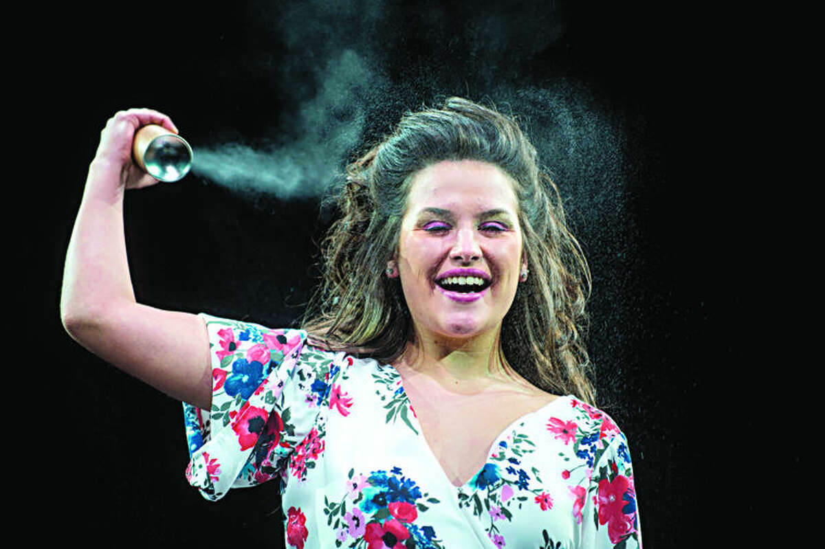  Northwood University senior Alyssa Green sprays hairspray while walking down the runway in the 15th annual Northwood University Style Show at the Hach Center on Friday night. This year's show "Play with Fashion" was inspire by Broadway musicals with more than 70 students modeling outfits representing "The Lion King", "Rock of Ages", "Hairspray", "Phantom of the Opera" and "Chicago".