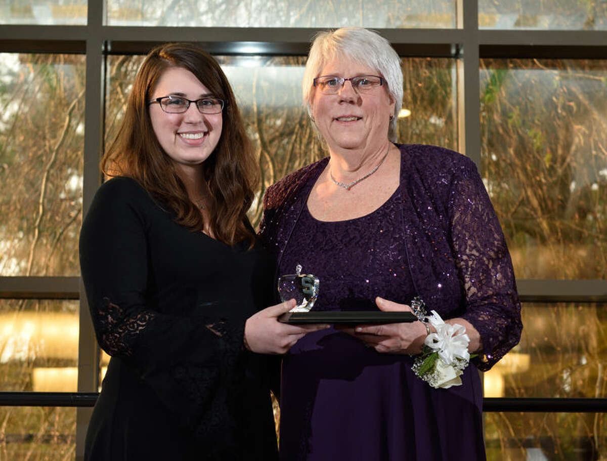 Mary Anne Forgach, right, was presented the Green Apple Teaching Award by former student Kayla Grotsky during a ceremony at Michigan State University in East Lansing. Grotsky graduated from MSU last month with a degree in computer science and credits Forgach for helping her go from failing math to advanced studies.