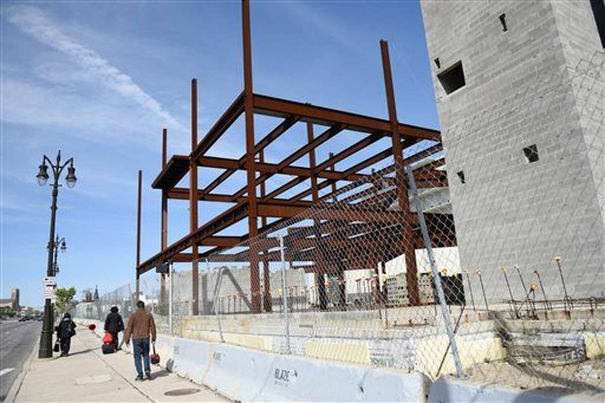 People pass the site of a suspended jail project in Detroit, Mich., Wednesday, April 27, 2016. Major League Soccer is eyeing the site as a possible home for a new soccer team in Detroit, part of a massive downtown development that would be built in the same area where the Tigers, Lions and Red Wings play. (Tanya Moutzalias /The Ann Arbor News - MLive.com Detroit via AP)