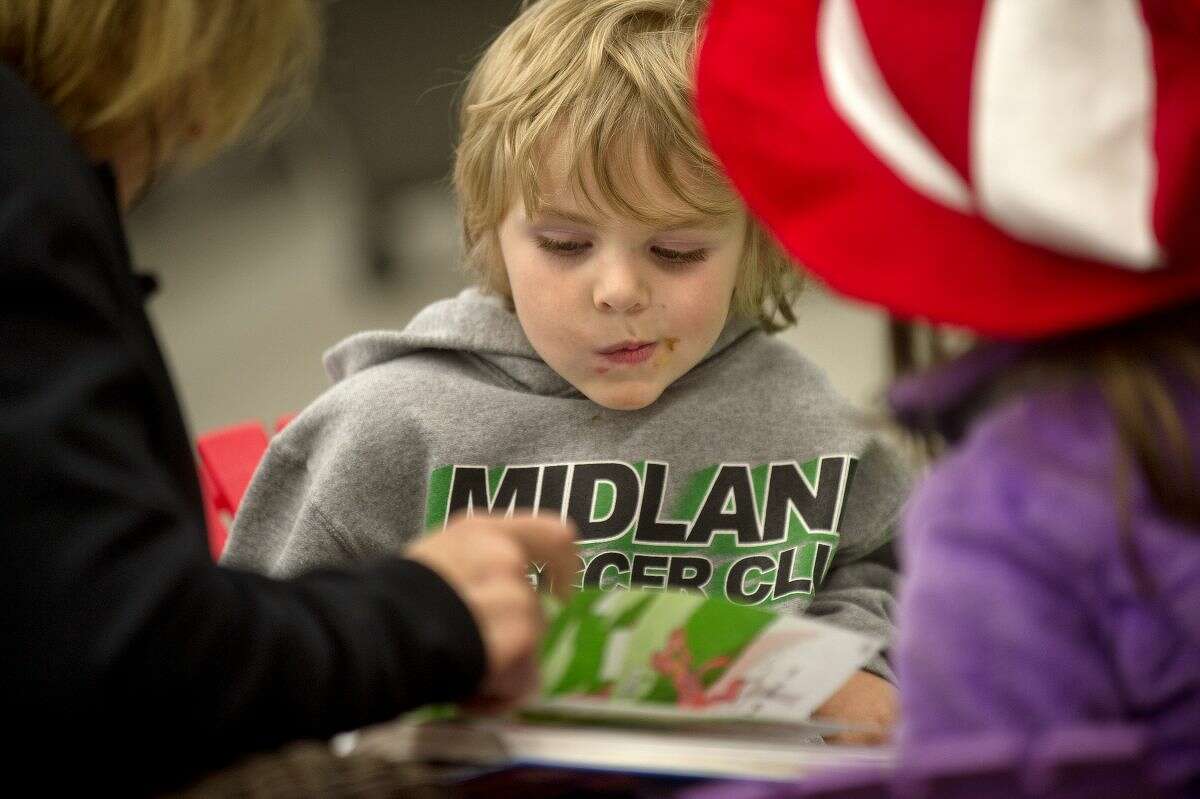 NICK KING | nking@mdn.net Brantley Mickler, 4, listens to Elaine White read 'Green Eggs and Ham' at Ace Hardware during Downtown Story Day on Saturday in Midland in 2016.