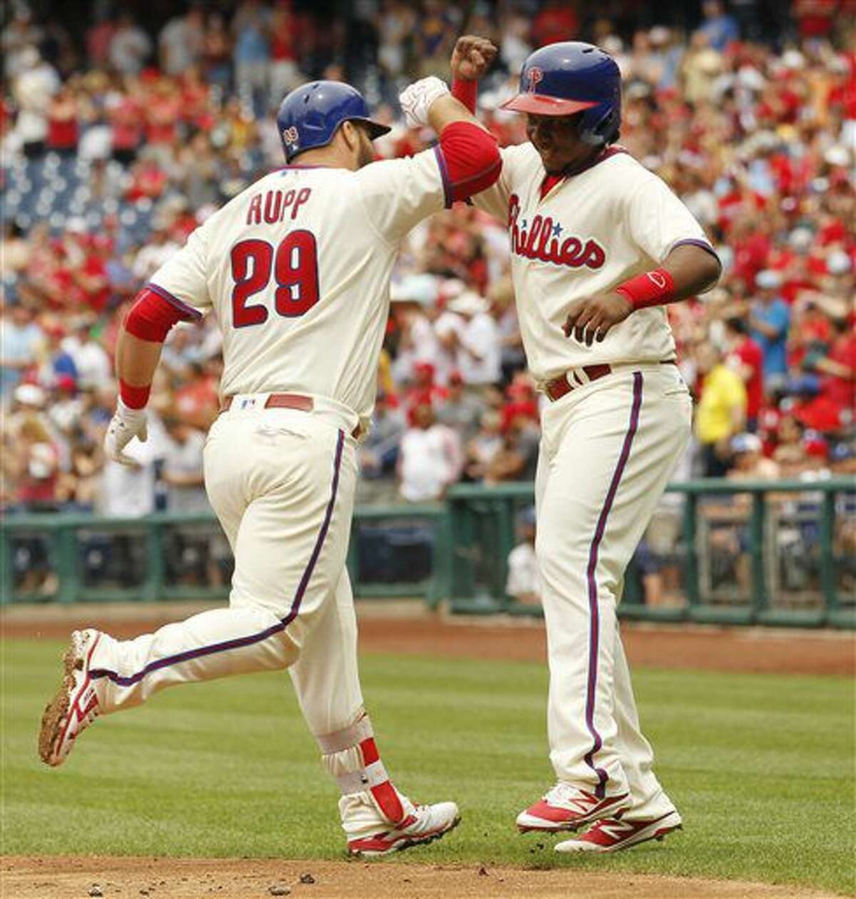 Philadelphia Phillies' Cameron Rupp, left, high-fives Maikel Franco after hitting a three-run home run during the first inning of a baseball game against the Kansas City Royals, Sunday, July 3, 2016, in Philadelphia. (AP Photo/Tom Mihalek)