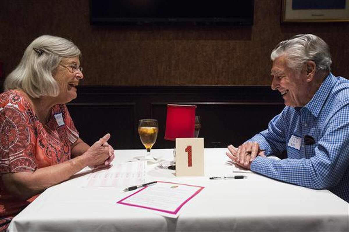 In a June 22, 2016 photo, Joanne Hale, 76, and Ted Eckhardt, 83, laugh together during their five minute date at a senior speed dating event at Bob's Chop and Steakhouse in San Antonio. (AP Photo/San Antonio Express-News, Brittany Greeson)