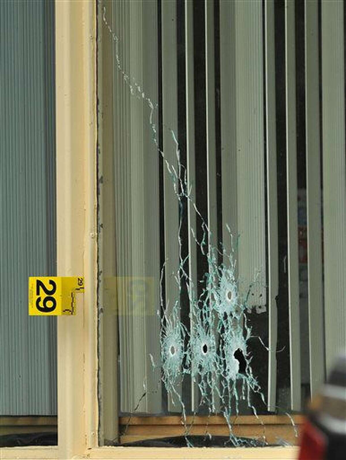 Bullet holes show in a window of a Days Inn Hotel office from a shooting early Thursday morning, July 7, 2016. A newspaper carrier was killed and four other people were wounded when a man opened fire, first at the Days Inn and then on cars traveling along a parkway in East Tennessee early Thursday morning. (Andre Teague/Bristol Herald Courier via AP)