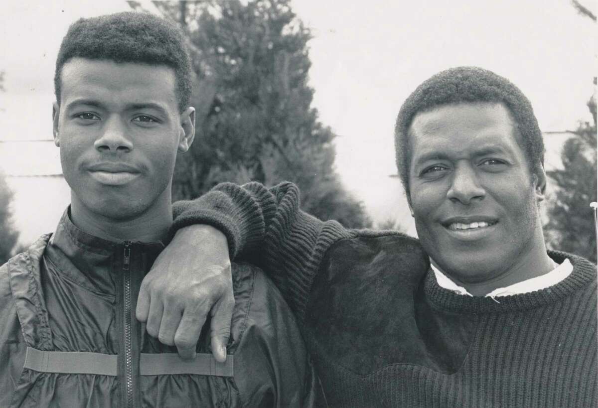 Original caption dated May 18, 1989: "Ken Griffey Jr. and Sr. stand for a father-and-son portrait till (see other photo) dad gives the kid a bad time about his recent notoriety by covering Junior's face." Seattle P-I Collection image number 2000.107.079.17.14