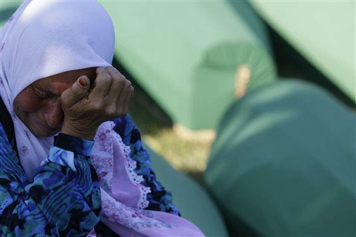 Una mujer bosnia ral lado de un ataúd con los restos de un familiar que murió en la masacre de Srebrenica, durante una ceremonia para enterrar a 127 víctimas de la masacre en el memorial Potocari, cerca de Srebrenica, a 150 kilómetros (94millas) a noreste de Sarajevo, Bosnia y Herzegovina, el lunes 11 de julio del 2016. Hace 21 años, el 11 de julio de 1995, soldados serbios invadieron el enclave bosnio Srebrenica, de población musulmana, y ejecutaron a unos 8.000 hombres y niños musulmanes, lo que las cortes internacionales han calificado de genocidio, y víctimas recién identificadas están siendo enterradas de nuevo en Srebrenica. (Foto AP /Amel Emric)