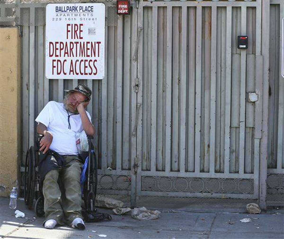 Un hombre duerme en una silla de ruedas en un vecindario donde viven muchos indigentes, el miércoles 6 de julio de 2016 en San Diego. (AP Foto/Lenny Ignelzi)