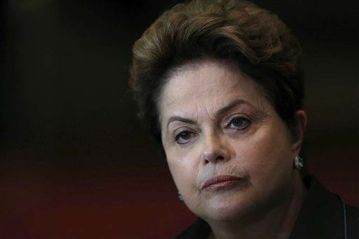 ARCHIVO - En esta fotografía de archivo del 6 de octubre de 2014, la presidenta brasileña Dilma Rousseff escucha una pregunta durante una conferencia de prensa en su campaña de reelección en el Palacio Alvorada en Brasilia. En una carta a una comisión del Senado leída por su abogado principal el miércoles 6 de julio de 2016, Rousseff le dijo a la comisión que sopesa si la retira permanentemente de su puesto que el caso en su contra es una farsa. (AP Foto/Eraldo Peres, archivo)