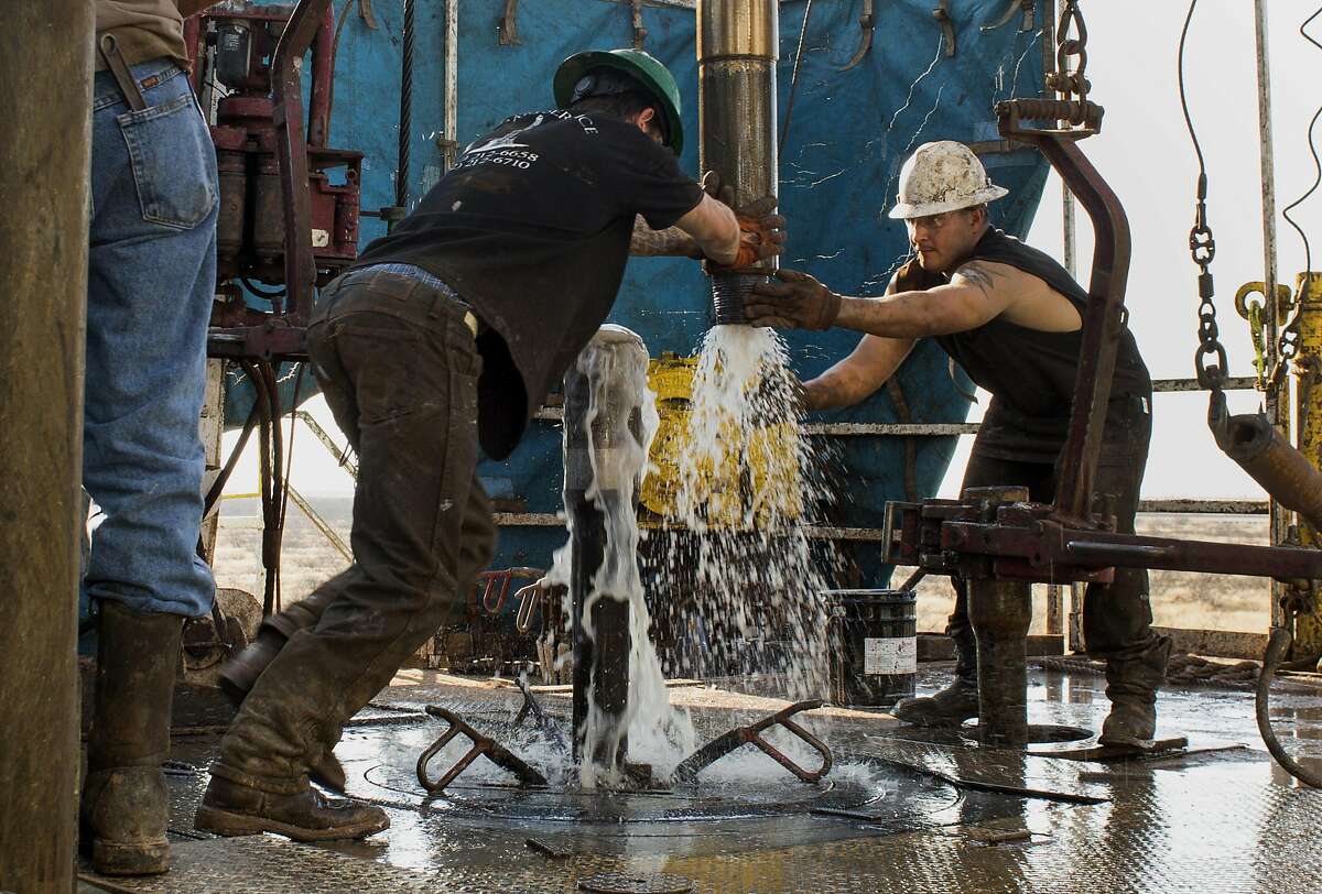 Workers connect drill bits and drill collars, used to extract natural petroleum, on Endeavor Energy Resources LP's Big Dog Drilling Rig 22 in the Permian basin outside of Midland, Texas.