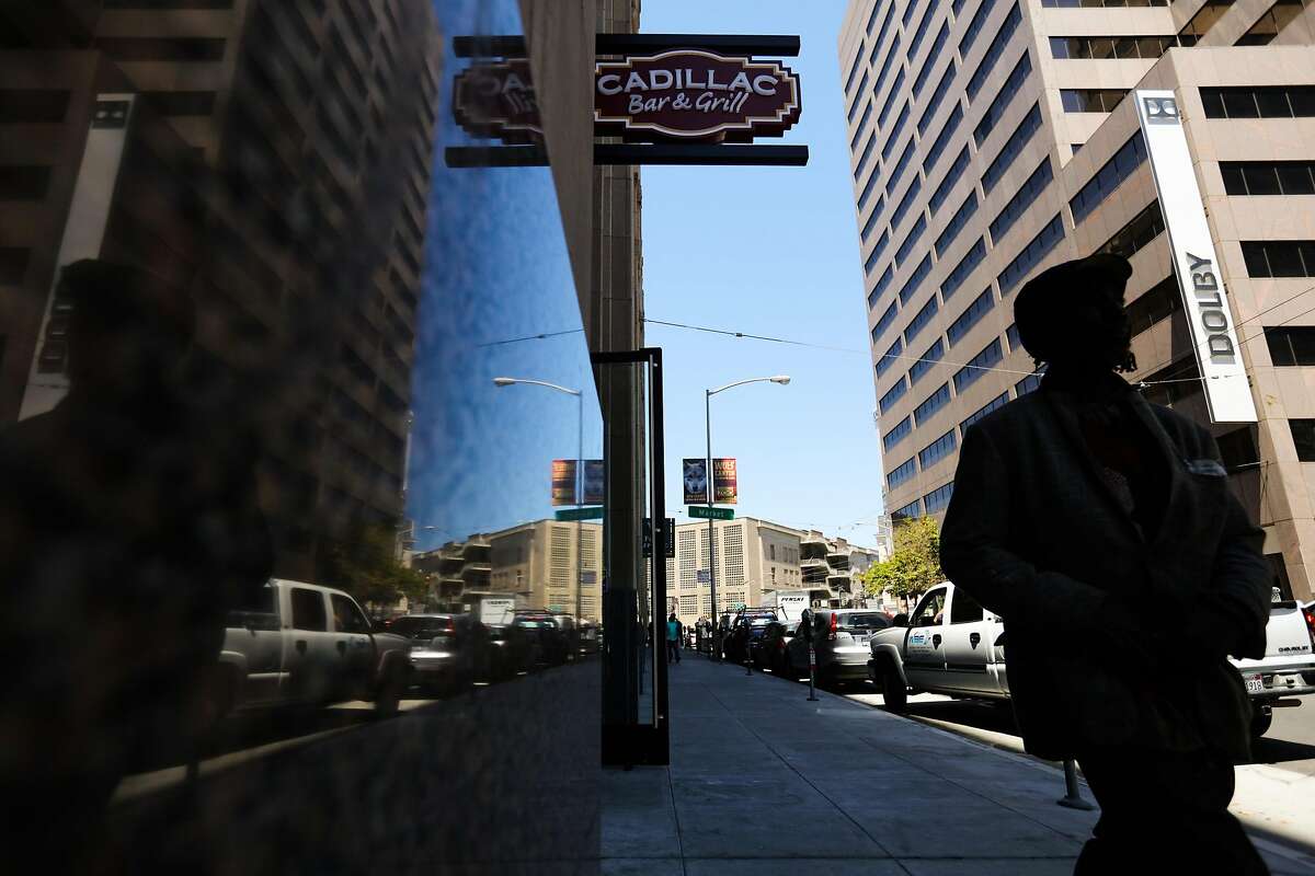 A man walks on 9th Street past restaurant Cadillac Bar & Grill in San Francisco, California, on Wednesday, July 13, 2016.