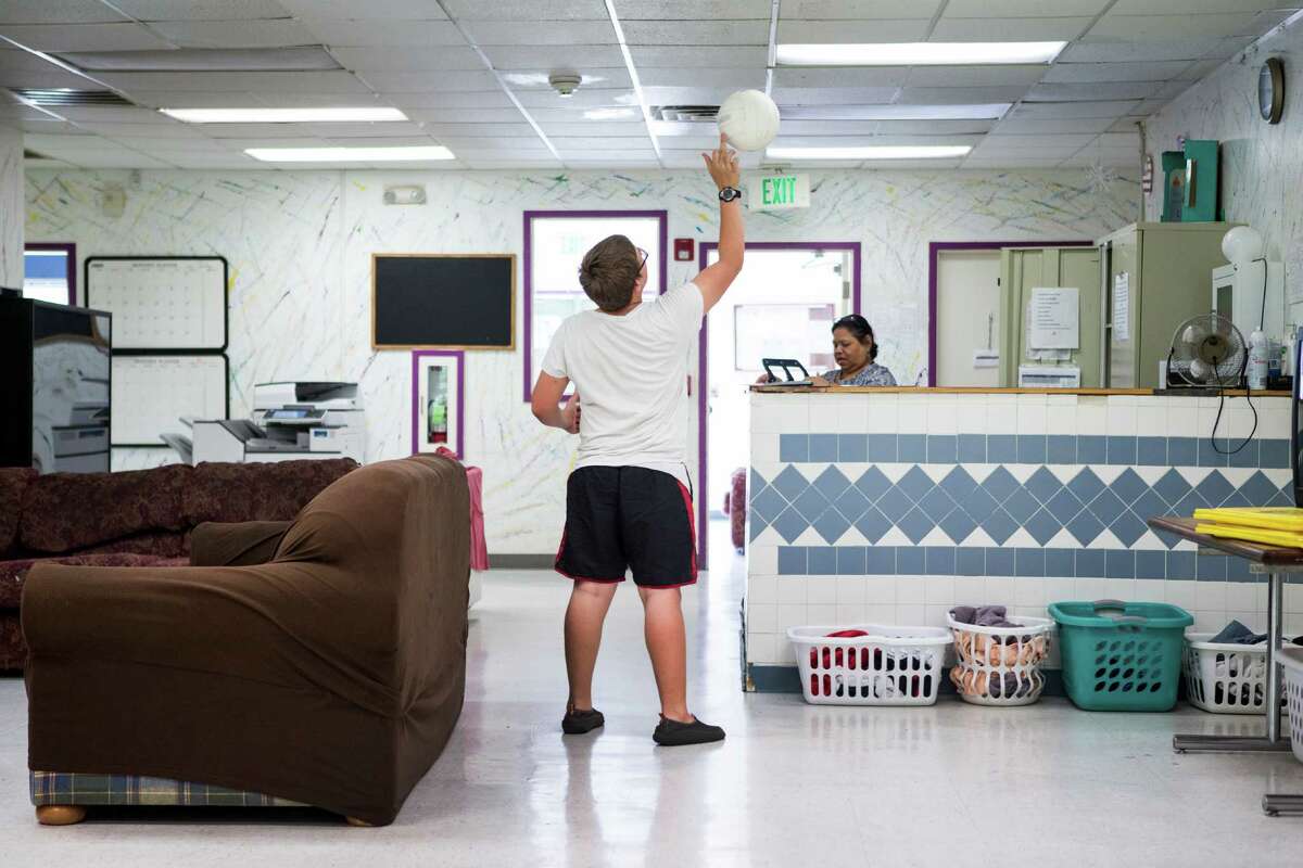 A resident of the Tejano Center for Community Concerns Emergency Shelter flips a ball in the air as he hangs out in the day room at the facility on Tuesday, July 12, 2016, in Houston. The emergency shelter stands at the site that city council is considering allocating $3.5 million in federal grants to help build an affordable housing complex geared toward youth aging out of foster care.