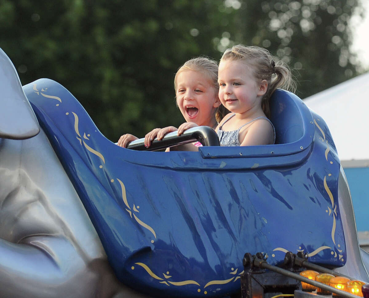 Greenwich kids, Vivian Partridge, 4, left, and Ava Kiraly, also 4, enjoy the flying elephant ride during the annual St. Catherine of Siena Church Carnival of Fun at the church in the Riverside section of Greenwich, Conn., Wednesday, July 13, 2016. The remaining nights for the Carnival of Fun are Thursday - Saturday, 6 p.m. - 11 p.m., at the church located at 4 Riverside Avenue in Greenwich. First prize in the Carnival of Fun raffle ($25 per ticket) is a red metallic 2016 BMW 228i.