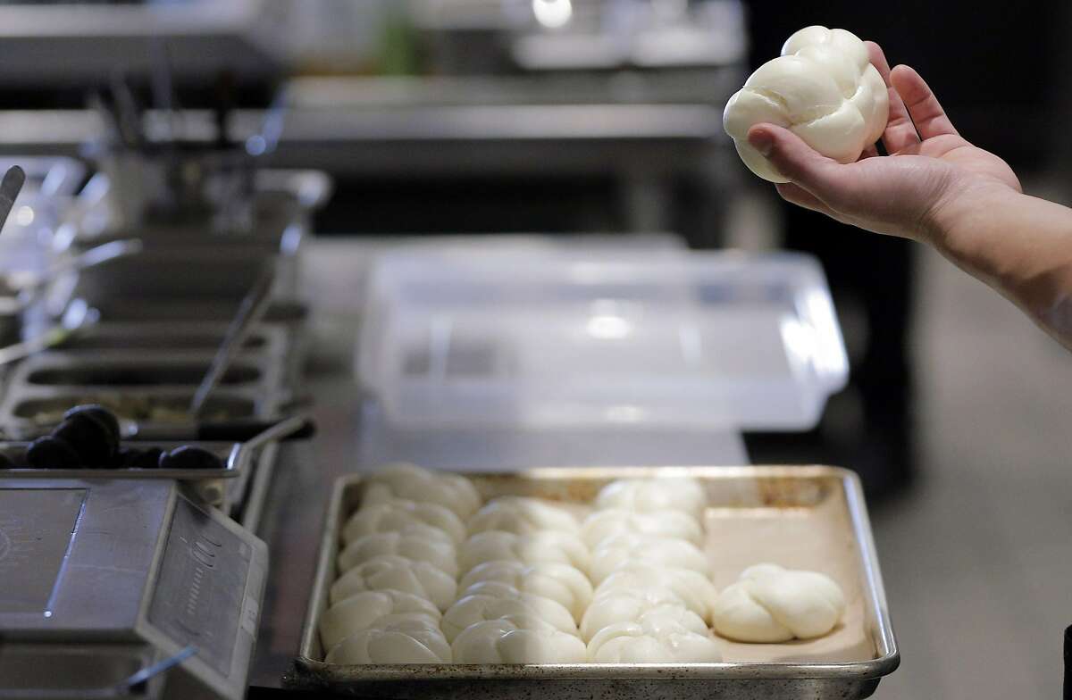 Brandon Chang, a line cook at Mister Jiu's, examines a bun as he helps to prep dinner service at the restaurant in San Francisco, Calif., on Tuesday, July 12, 2016.