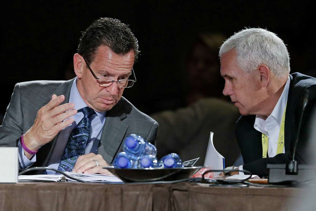 Connecticut Gov. Dan Malloy, left, talks with Indiana Gov. Mike Pence, right, during a meeting on jobs and education at the National Governors Association convention Saturday, July 12, 2014, in Nashville, Tenn.