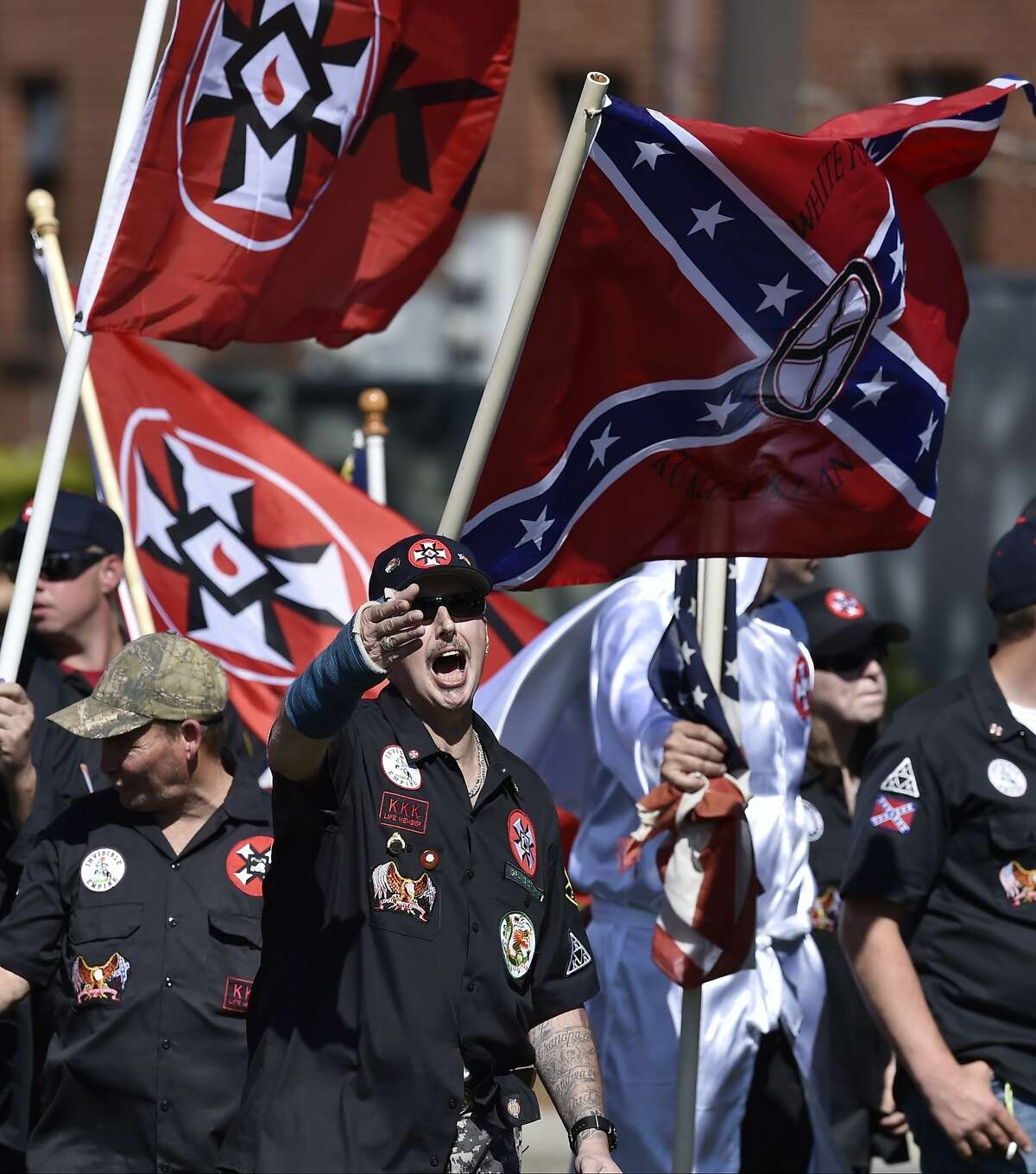 In this Saturday, April 23, 2016 photo, Loyal White Knights Grand Dragon Will Quigg of Anaheim, Calif., center, shouts to protestors during a "White Pride," rally, in Rome, Ga. The name "Ku Klux Klan" evokes horror for many, but what is the organization today? The AP is interviewing imperial wizards and grand dragons, a watchdog group and others to develop a portrait of the KKK as it exists in 2016. (AP Photo/Mike Stewart)