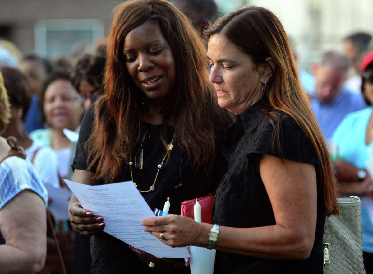 Pertrinea Cash, of Trumbull, left, and April Obermeyer, of Fairfield, sing together during a short service before a candlelight vigil held at the First Baptist Church of Stratford on Stratford Avenue in Stratford, Conn. on Thursday July 14, 2016. The vigil was held in response to the violent attacks against citizens and police last week. The vigil was a collaboration between the First Baptist Church of Stratford, First Church Congregational in Fairfield and the Stratford Interfaith Clergy Association.