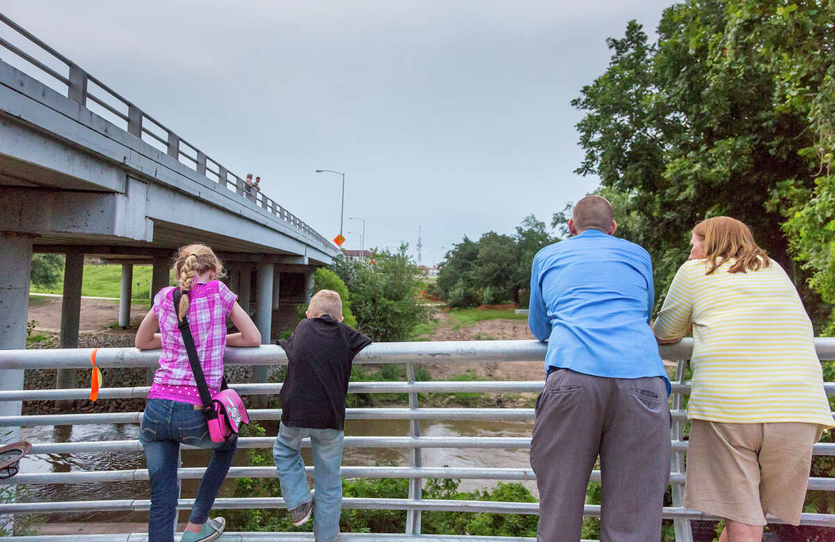 Adults and children gather at the Waugh Street Bridge to watch the nightly emergence of Mexican free-tailed bats.﻿