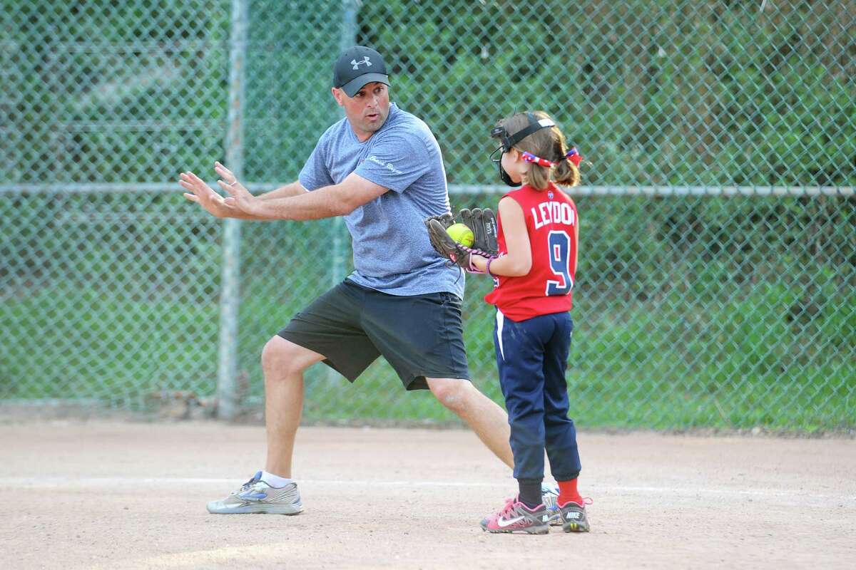Stamford girls Babe Ruth 8U coach Bryan Fox works with Anne Leydon on the proper stance during practice at Troy Field on Tuesday, July 12, 2016.