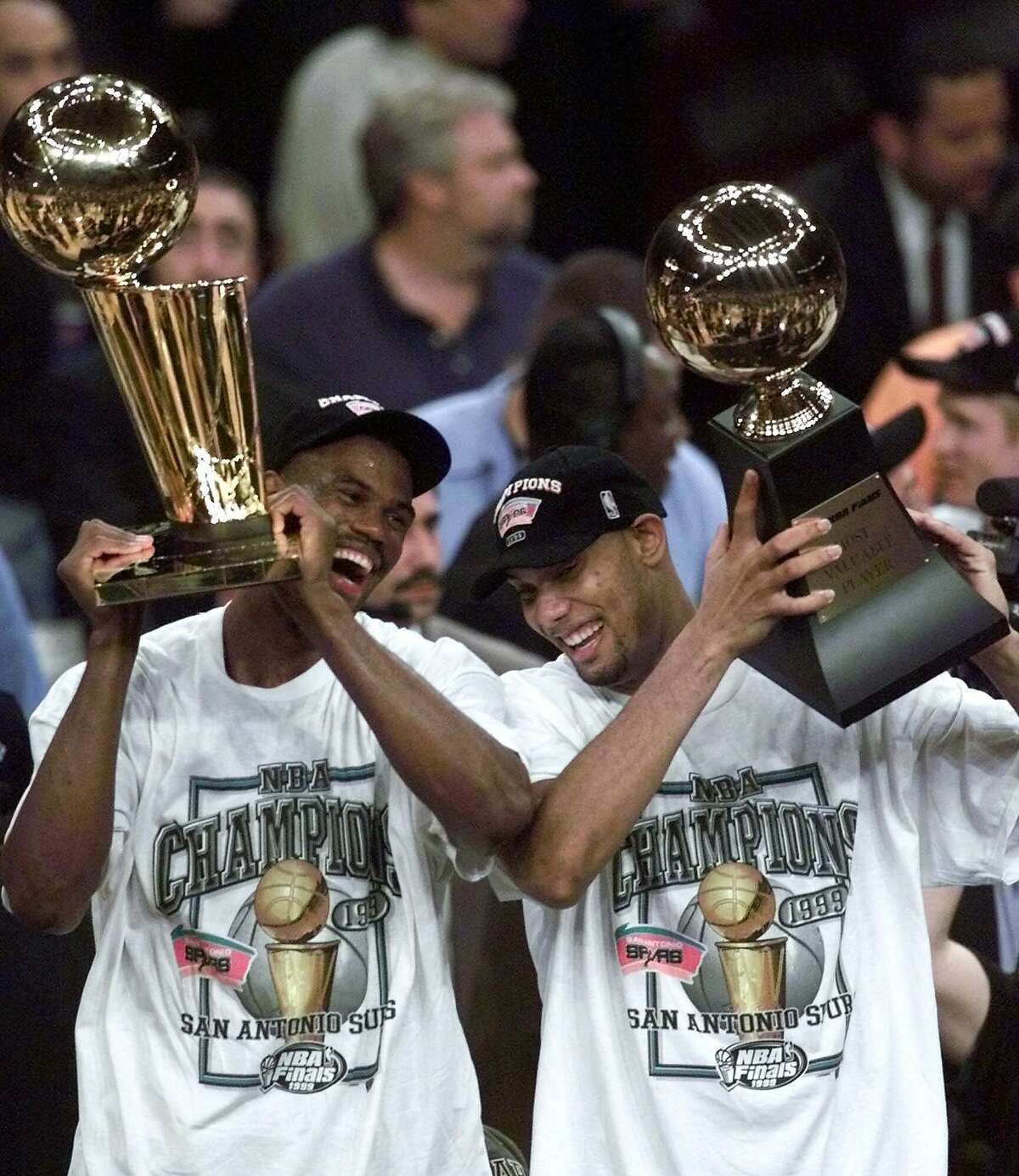 The San Antonio Spurs' David Robinson, left, holds the NBA championship trophy as teammate Tim Duncan holds the Most Valuable Player trophy after defeating the New York Knicks 78-77 in Game 5 of the 1999 NBA Finals on June 25, 1999, at New York's Madison Square Garden.