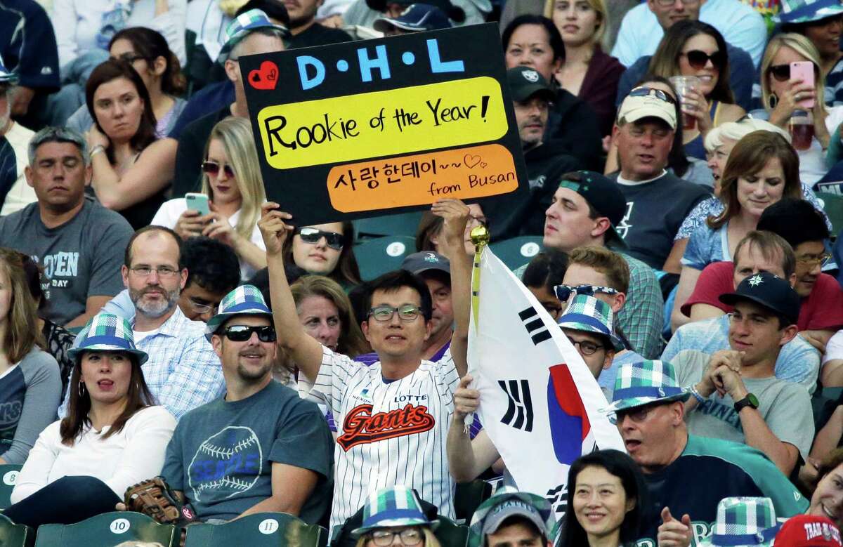 A fan in the stands holds a sign calling for Seattle Mariners first baseman Dae-Ho Lee to be named rookie of the year, during a baseball game between the Mariners and the Houston Astros, Friday, July 15, 2016, in Seattle. (AP Photo/Ted S. Warren)