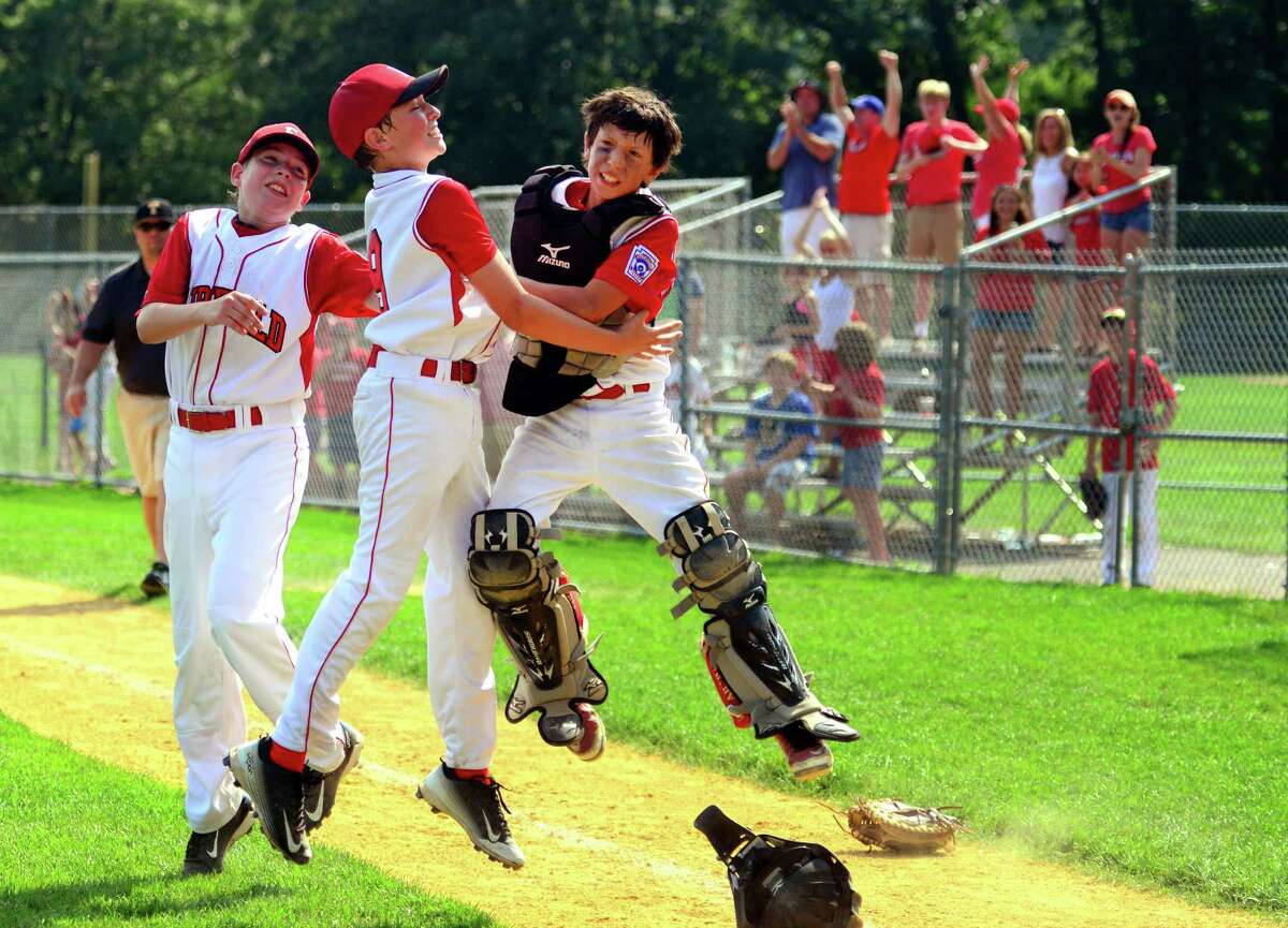 Fairfield American pitcher Jack Gremse, center, leaps into the air with catcher Matt Vivona to celebrate the team's win over Trumbull National in District 2 little league tournament action at Unity Park in Trumbull, Conn. on Saturday July 15, 2016.