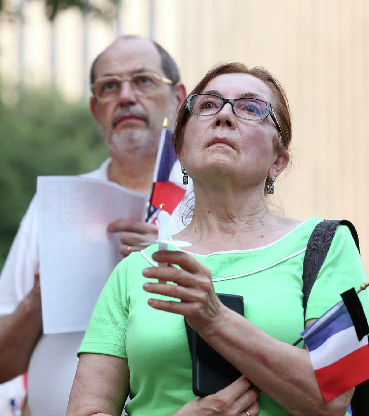 Sonia Tabarovsky, right, listens as the Consul General of France speaks during a vigil for the victims of the Nice attacks, at Hermann Square, Saturday, July 16, 2016, in Houston.