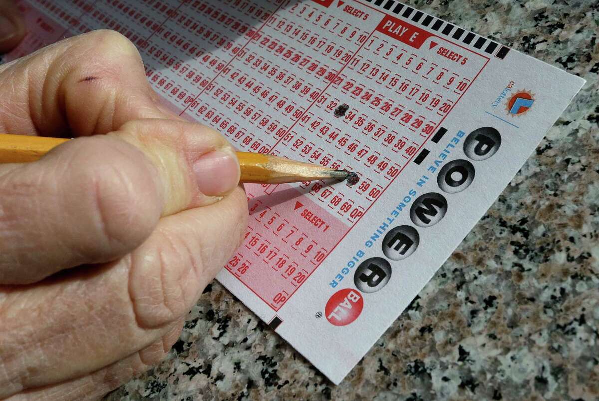 A lottery player fills out numbers on a Powerball form.