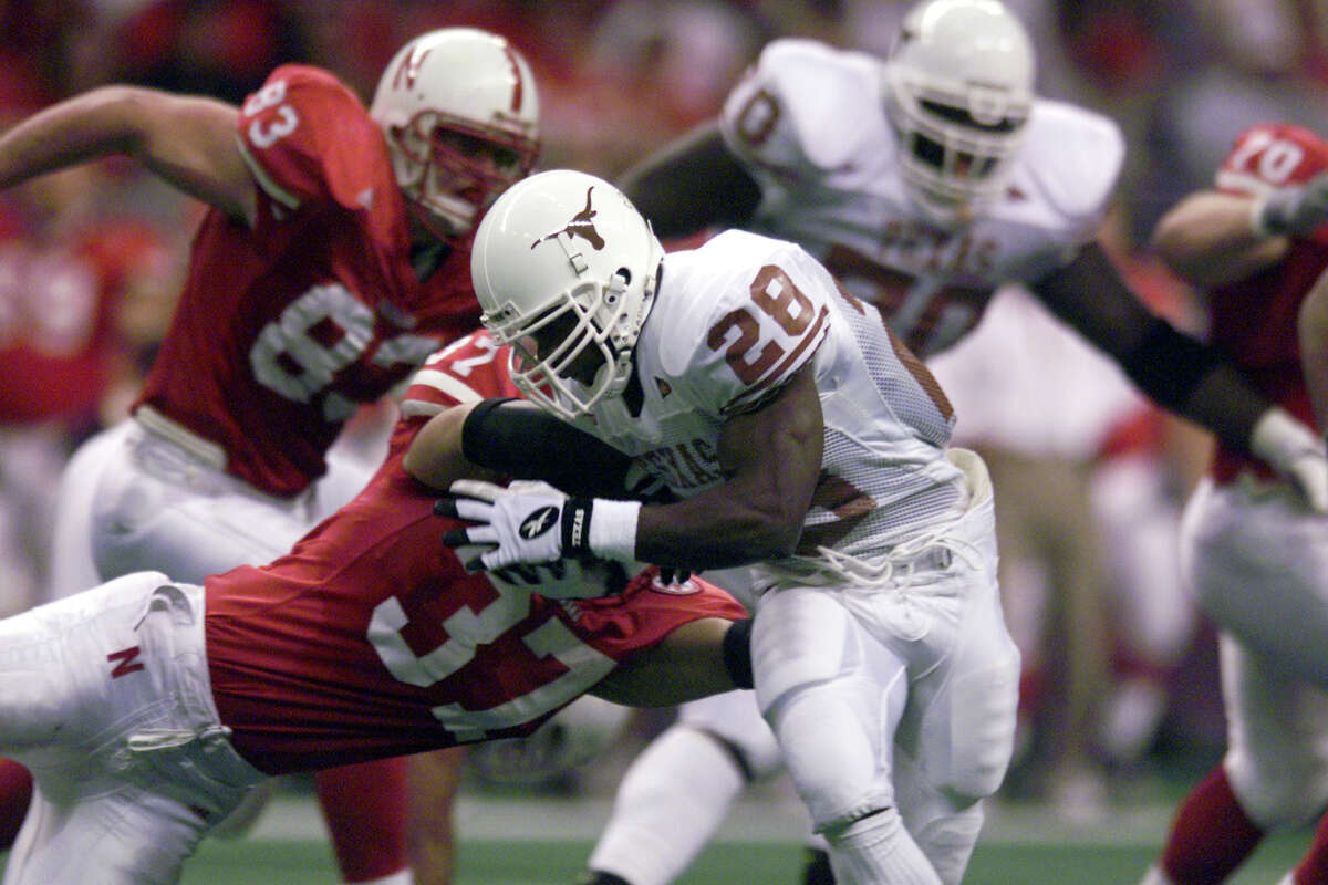 Texas Longhorns running back Victor Ike is brought down by the Nebraska Cornhuskers’ Tony Ortiz during the Big 12 championship game at the Alamodome on Dec. 4, 1999.