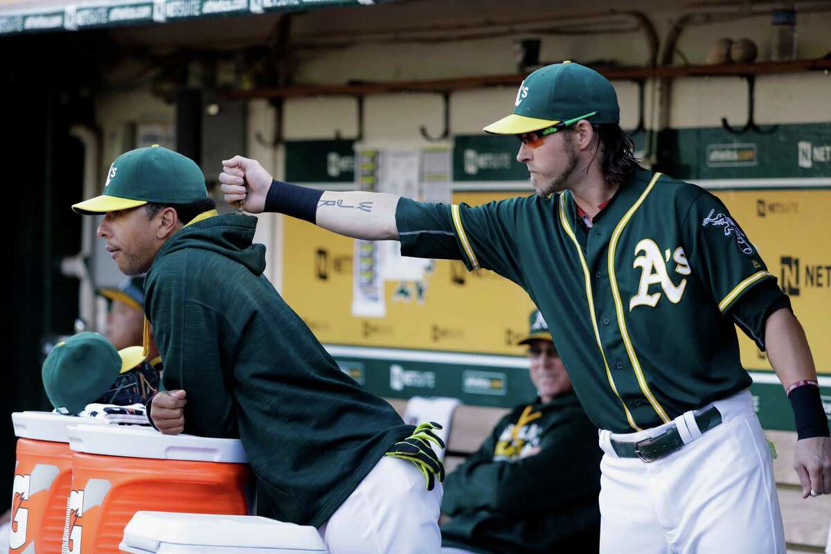 Oakland Athletics' Josh Reddick, right, places sunflower seeds inside the hood of Tyler Ladendorf during the first inning of a baseball game against the Houston Astros Monday, July 18, 2016, in Oakland, Calif. (AP Photo/Marcio Jose Sanchez)