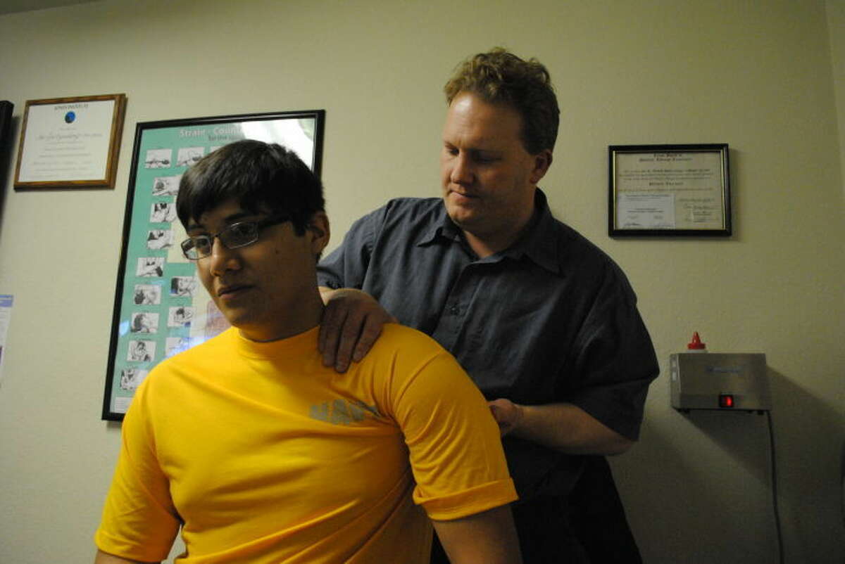 Joe Switzenberg adjusts Plainview High School student Adrian Torres, who came in to see Switzenberg with pain in his lower back.