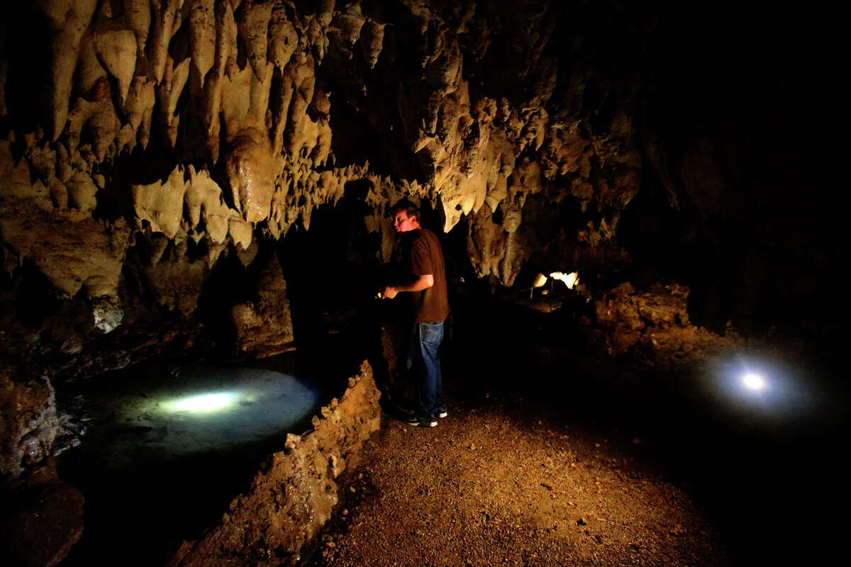 Cascade Caverns president Lance Kyle shines a flashlight on rock formations Thursday July 14, 2016 at the Bourne, Texas tourist attraction. Kyle is concerned about a proposal for a utility in the area to drill a new well nearby, and how it might affect spring flows in the cavern.