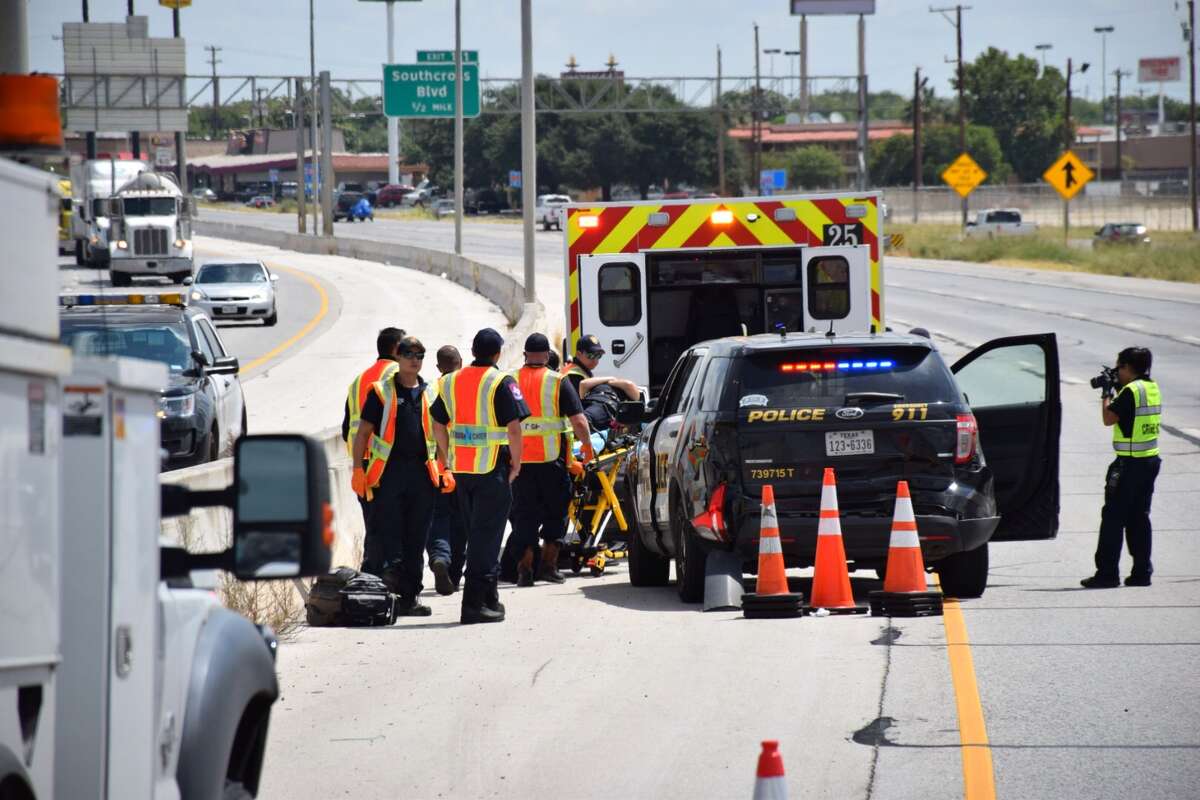 Emergency crews work to clear the scene of a three-car crash involving a San Antonio Police Department officer and cruiser, a CPS truck and a sedan on Interstate 35 near Southwest Military Drive on July 19, 2016.