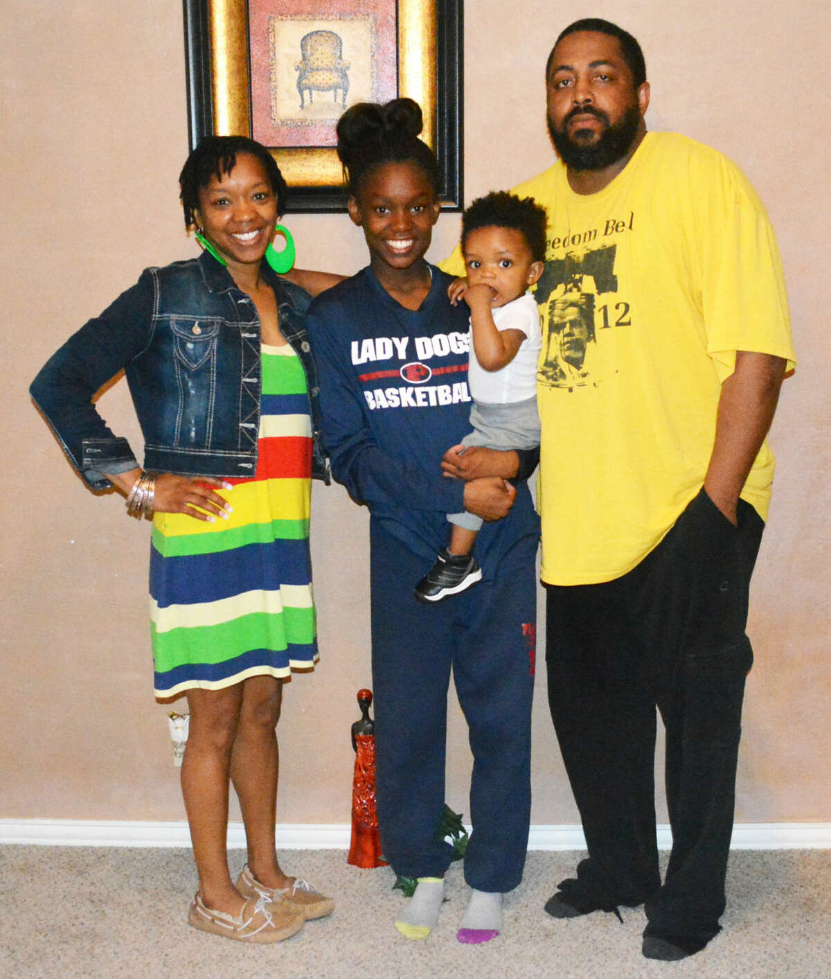 Plainview track athlete Kaizha Roberts, center, holds her brother, 11-month-old Bailor J. Myers as she is flanked by her parents, LaTosha Myers, left, and Bennie "B.J." Myers, right. Roberts, a Plainview High School sophomore, will have a chance to go to Australia and compete in a track meet in July as part of the Down Under Sports program.