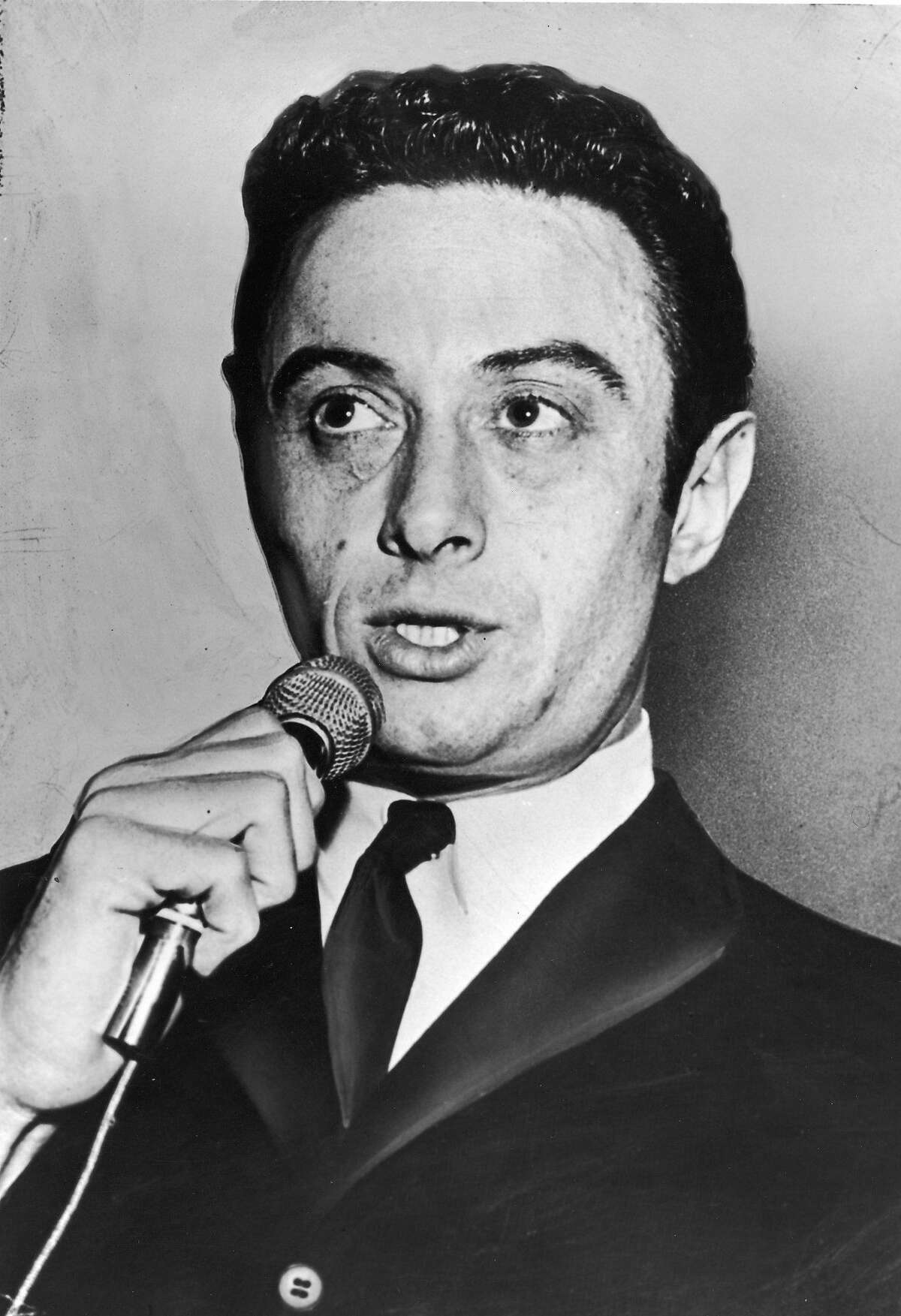 American comedian Lenny Bruce (1925 - 1966) holds a microphone while performing, 1950s. (Photo by Hulton Archive/Getty Images)