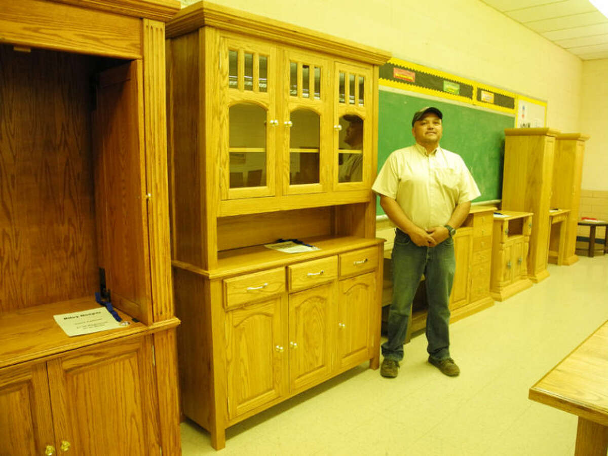 Edward Vuittonet, who received the ITEEA Teacher Excellence Award for 2013-14, stands next to a china cabinet built by Brennon and Breana Amador in Kress High School’s ITE class.