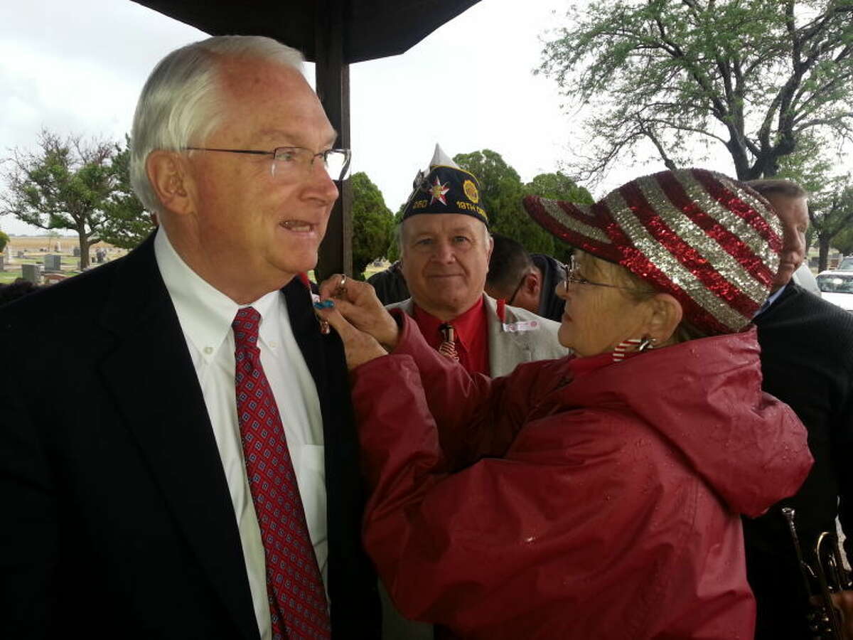 Ralph Langley watches on as American Legion Auxiliary Post 260 Chaplain Jerree McKeeman pins a Memorial Day poppy on U.S. Rep. Randy Neugebaur. On Monday, a crowd braved the elements to honor the nation’s valiant defenders during Plainview Memorial Day services. Check out more photos of the ceremony on myplainview.com.