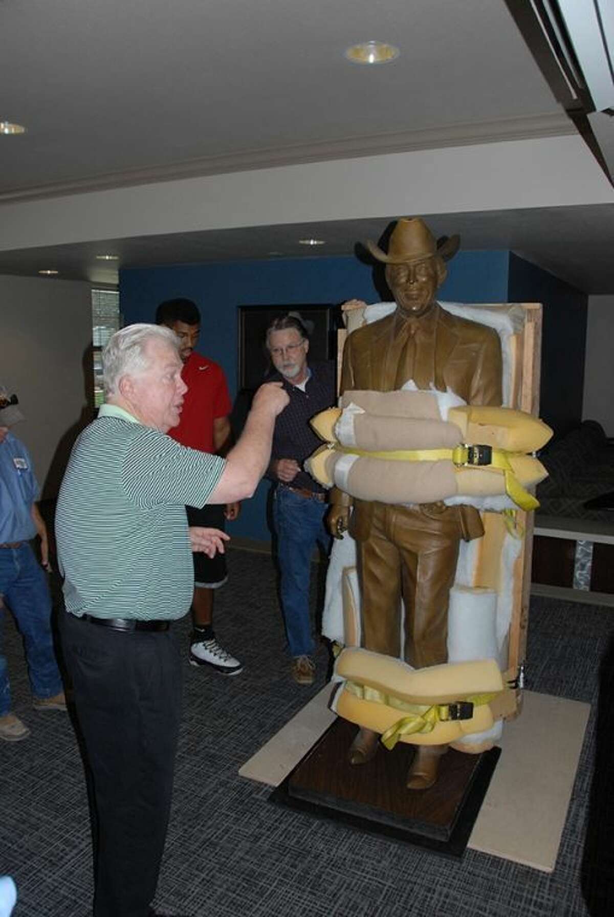t University Executive Director of Advancement Mike Melcher instructs workers on where to place the 800-pound Jimmy Dean statue in its temporary home in Jimmy Dean Hall. The statue will be moved to the Jimmy Dean Museum when it is complete in August 2015.