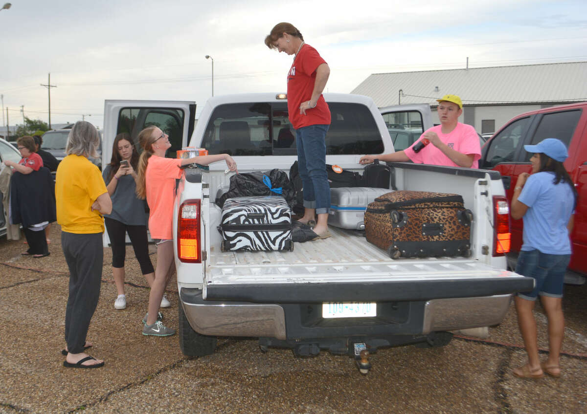 Doug McDonough/Plainview Herald Colti Wright (left) and Lisa Wright have a mother-daughter moment while loading luggage early Monday for a trip to State 4-H Roundup in College Station.