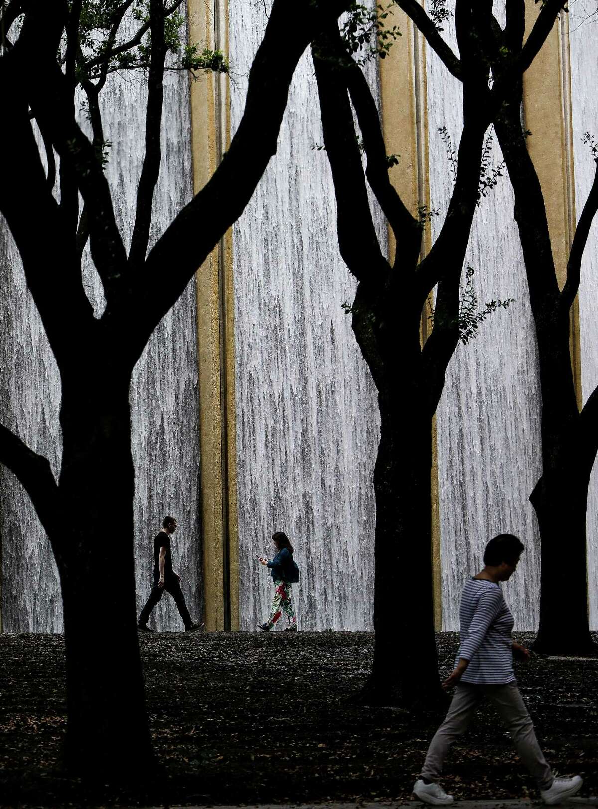 People walk by the Gerald D. Hines Waterwall Park Monday, June 27, 2016 in Houston. ( Michael Ciaglo / Houston Chronicle )