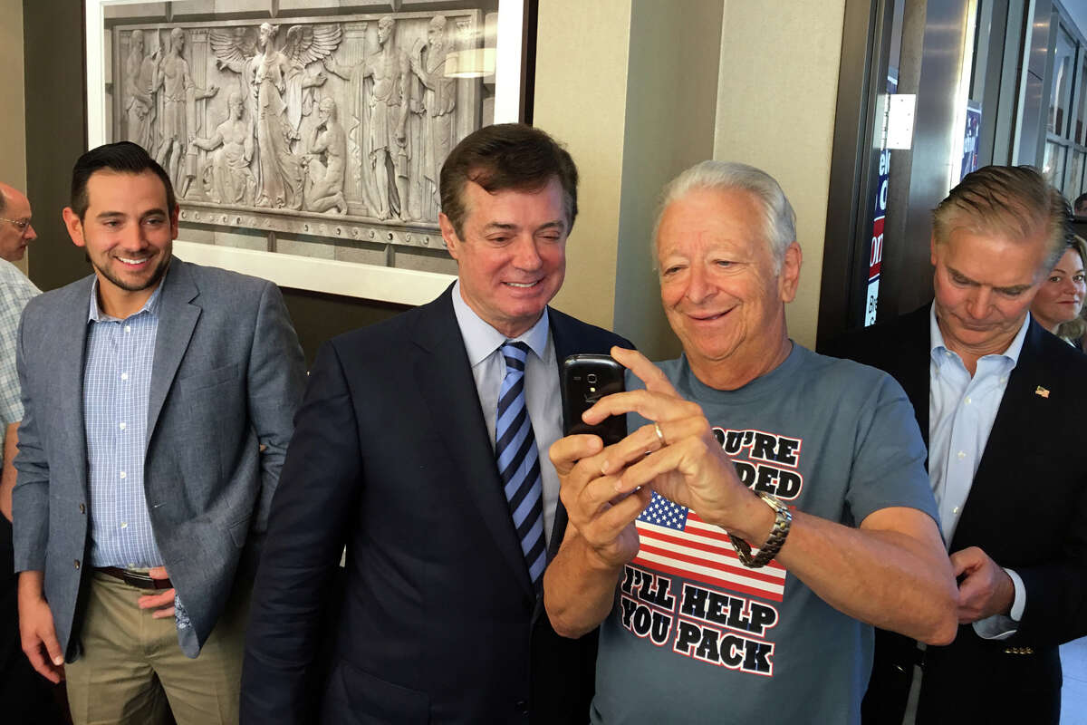 Trump campaign manager Paul Manafort, center, takes a selfie with former Norwalk mayor and current Ridgefield resident Richard Moccia during a Connecticut GOP breakfast .