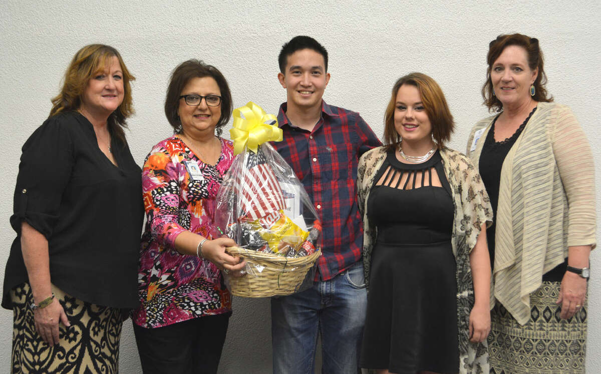 Marine veteran Brian Tran and wife Kayla (center) hold a gift basket from Runningwater Draw RSVP, presented by Angie Nelms (left), Military Veteran Peer Network; Irma Shackelford, RSVP executive director; and Karla Glowicki, county veteran service officer.