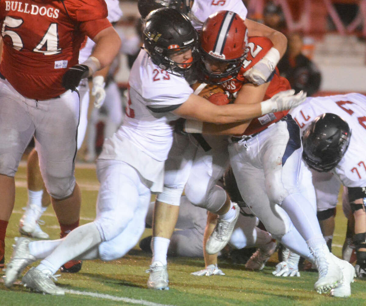 Plainview running back Wrangler Haresnape (12) runs into a Lubbock Cooper defender and gains some tough yardage up the middle in last week's game. The Bulldogs travel to San Angelo Lake View Friday night in search of their first district win.