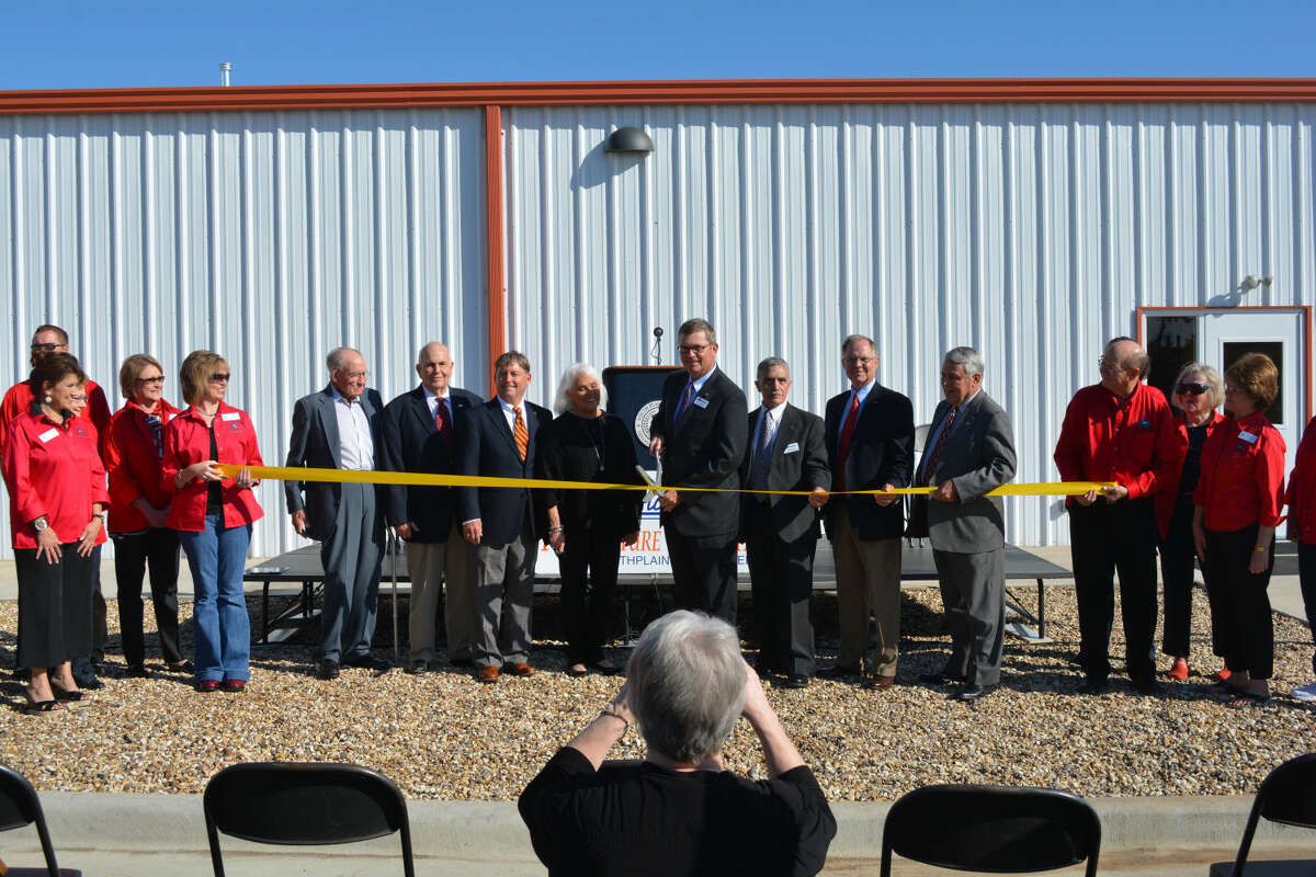 Doug McDonough/Plainview Herald Surrounded by college regents and other officials, South Plains College President Dr. Kelvin Sharp clips a ribbon Friday morning to formally open the Plainview Technology Center. Adjacent to the SPC Plainview Center at 1920 W. 24th, the $1.2 million facility expands the school’s workforce training capacity.