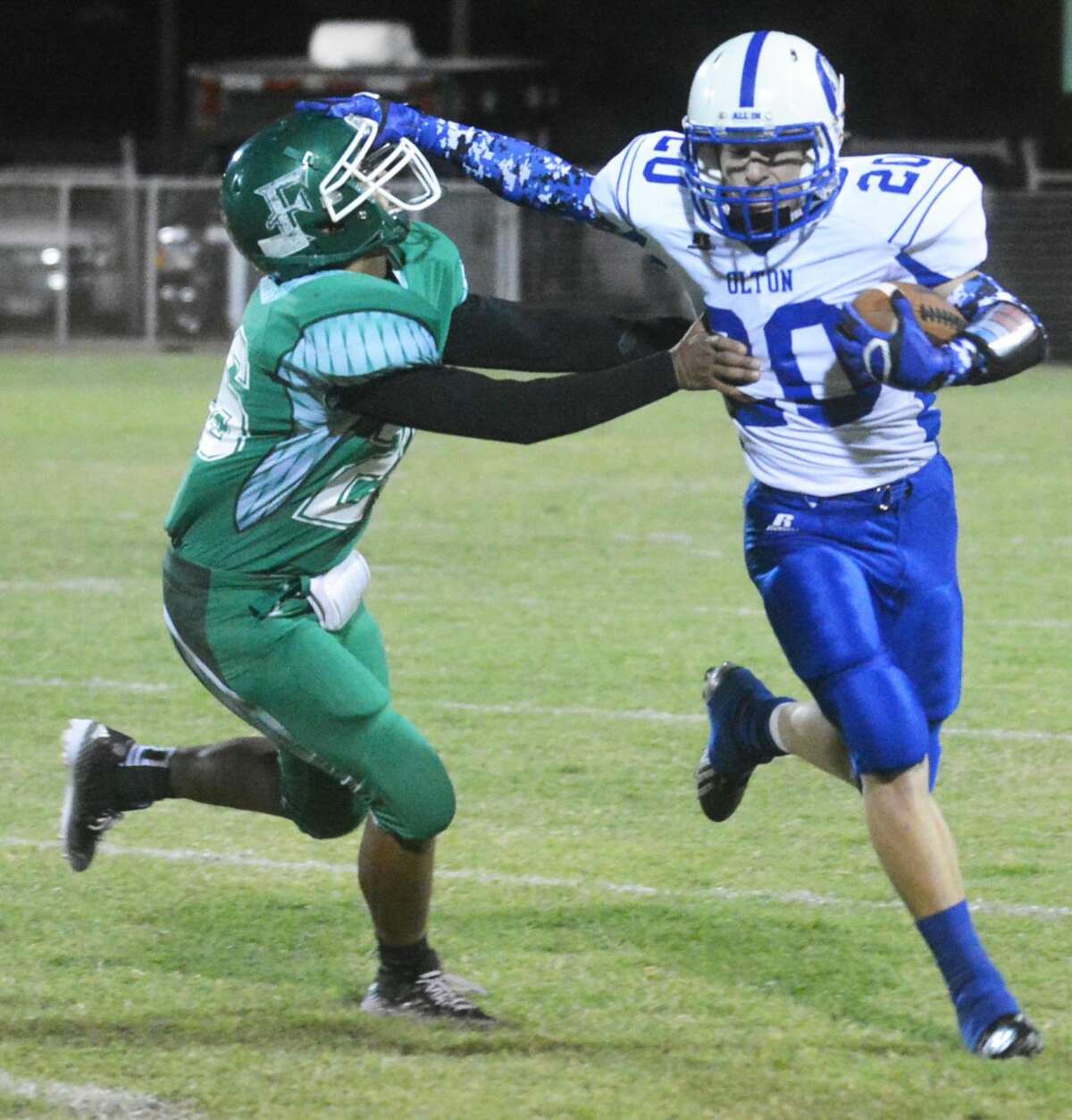 Olton receiver T.J. McCall (20) tries to break free from Floydada's Albert DeHoyas (26) during a district football game at Floydada Friday night. McCall caught three touchdown passes, but the Mustangs lost to the Whirlwinds, 24-19.