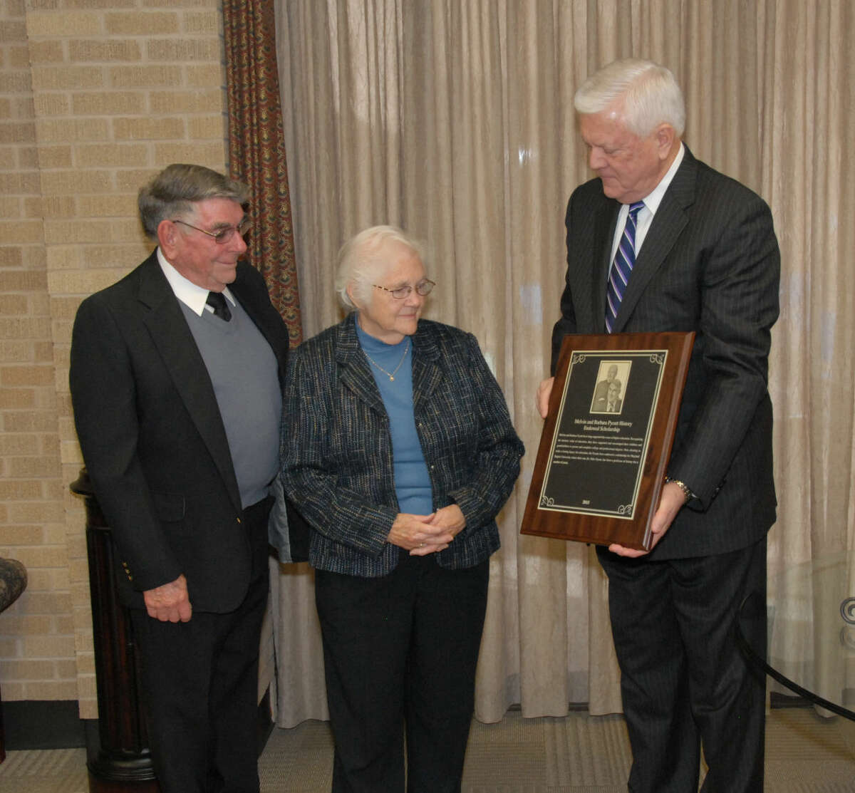 Wayland President Dr. Paul Armes (right) shows Melvin and Barbara Pyeatt, of Carlsbad, N.M., the scholarship plaque that will hang in McClung Center in honor of their newly endowed scholarship.