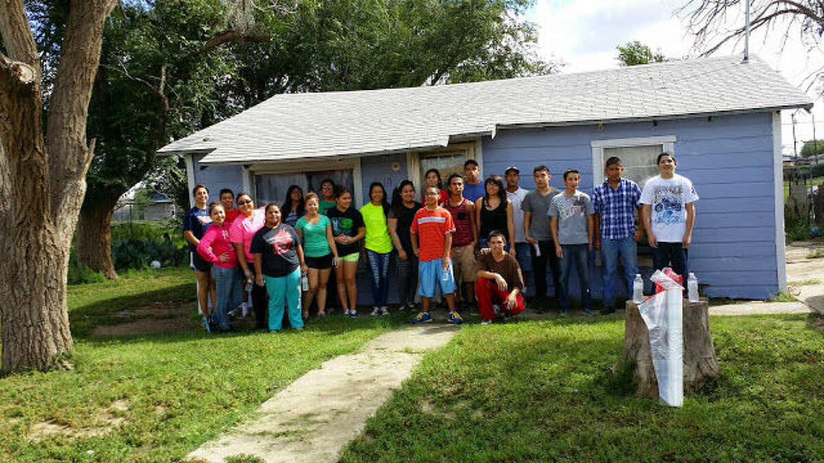 Above, members of the Our Lady of Guadalupe confirmation class stand next to a recently painted home. The group volunteered to paint and clean two houses this past September.