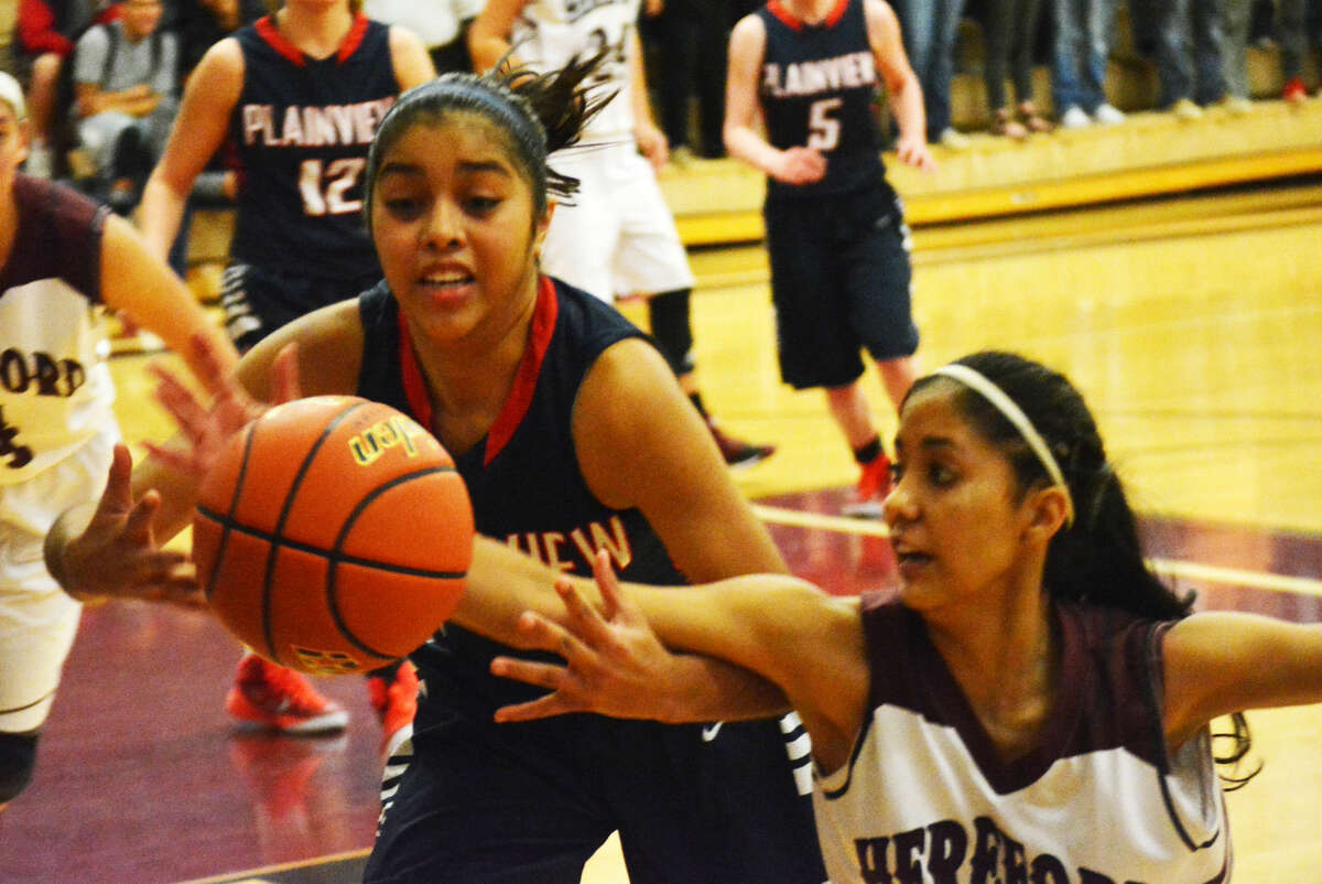 Plainview's Brittany Rincon (left) battles a Hereford player for possession of the basketball during a game in Hereford Tuesday night. The Lady Bulldogs fell to the Lady Whitefaces, 50-41.